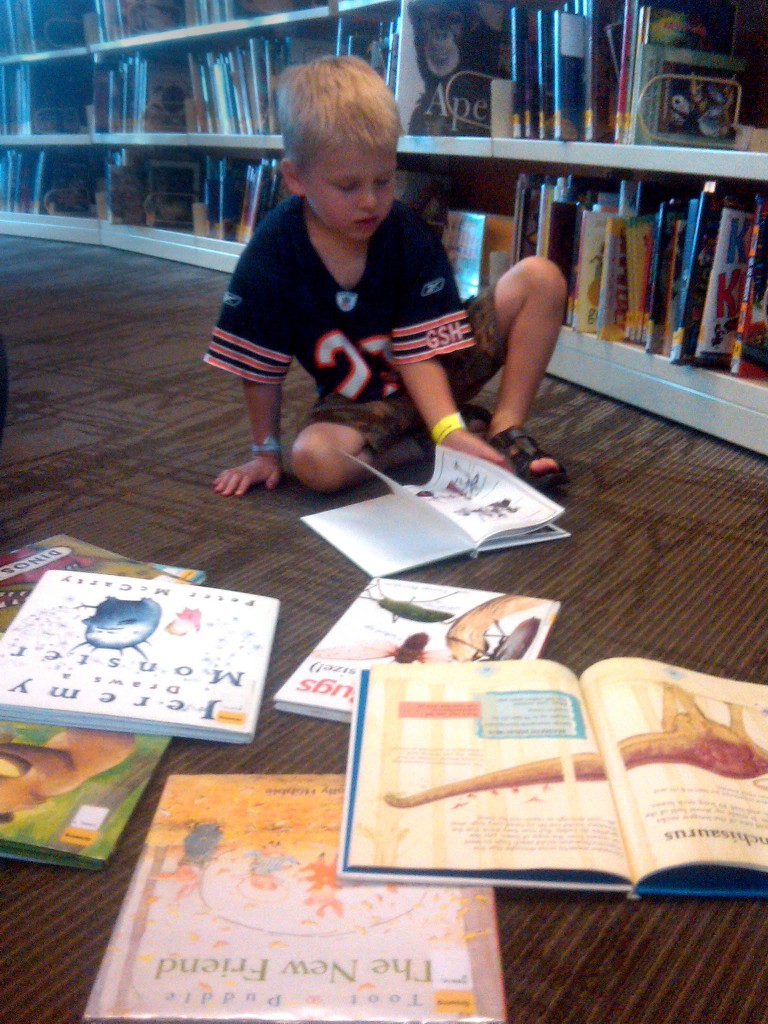 Child reading books at library