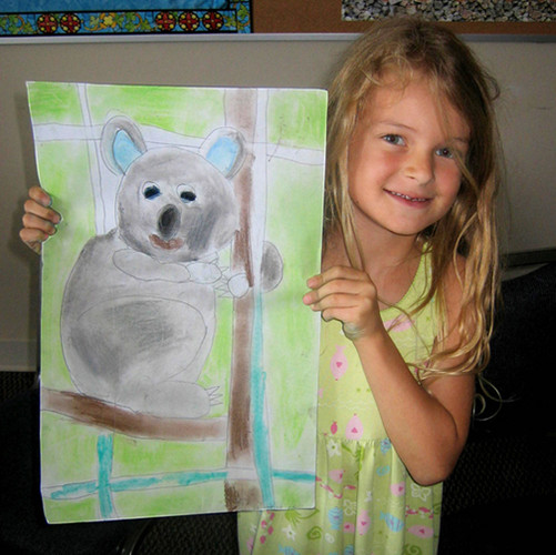 Young Rembrandts artist holding up koala drawing